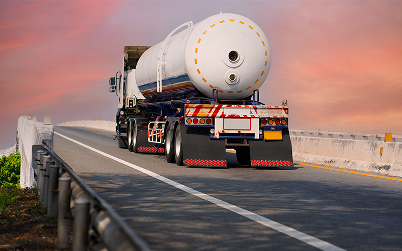 Large fuel tanker truck delivering diesel at industrial site